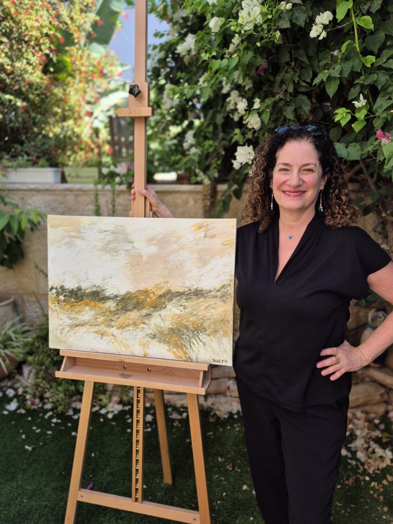 Sharon the artist smiling beside her large abstract acrylic painting on canvas